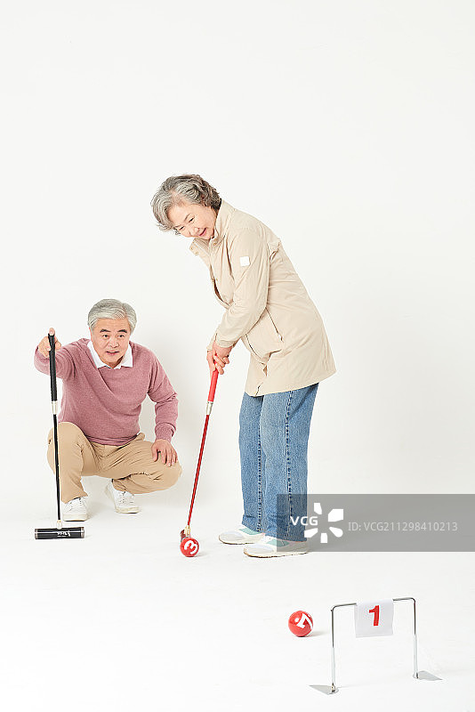 老年夫妇玩槌球，将球击入球门图片素材