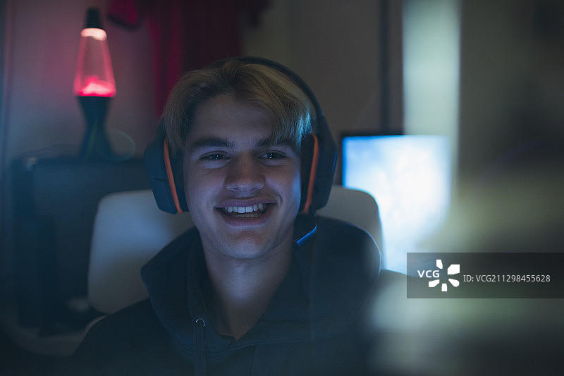 戴着耳机的微笑青少年男孩图片素材