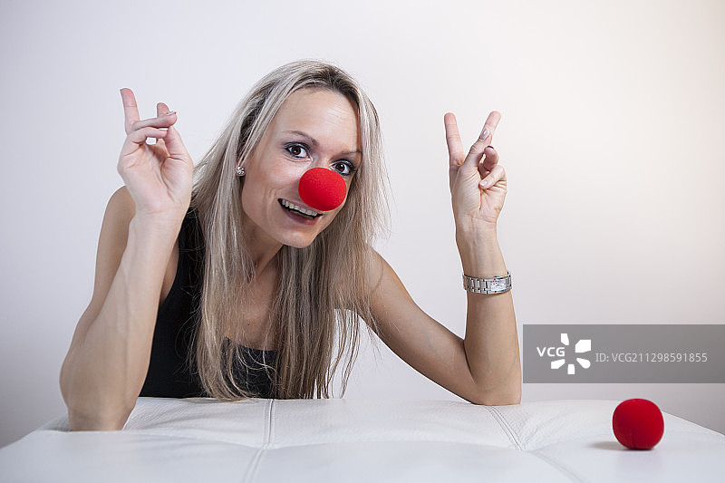 脸上带着红鼻子的年轻女人肖像 白色背景图片素材