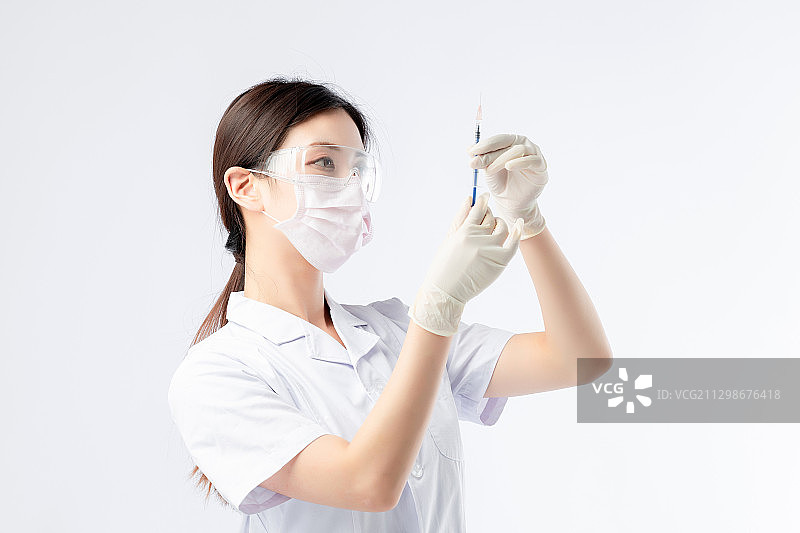 带着口罩,手拿针管的亚洲女护士图片素材