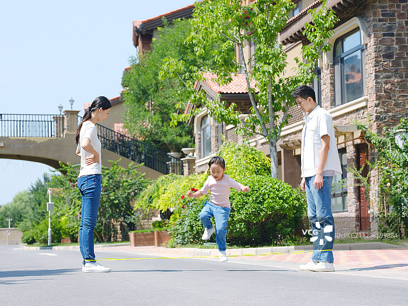 快乐的三口之家在户外跳绳图片素材