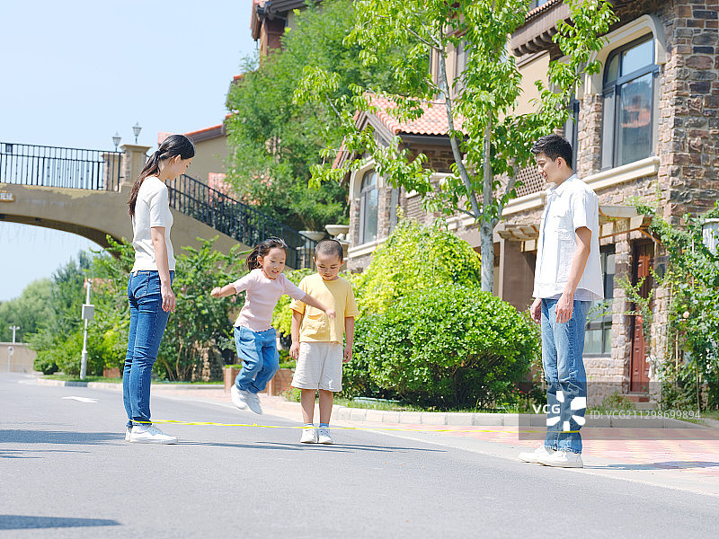 快乐的四口之家在户外跳绳图片素材
