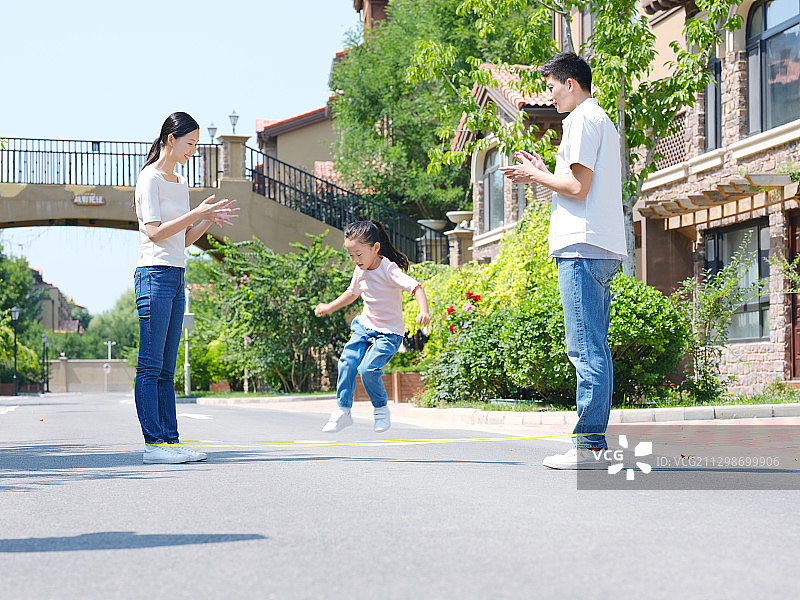 快乐的三口之家在户外跳绳图片素材