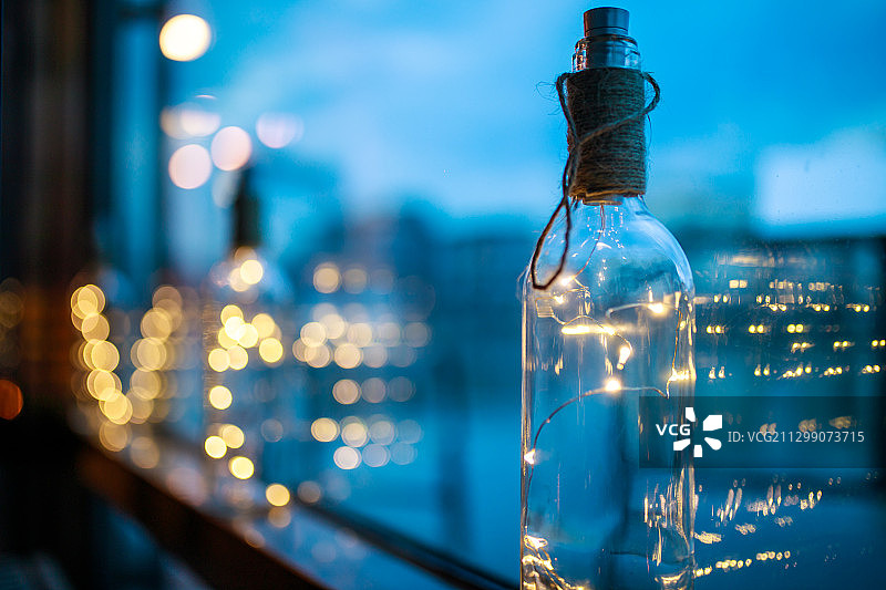 夜色中玻璃瓶中的灯珠和光斑图片素材