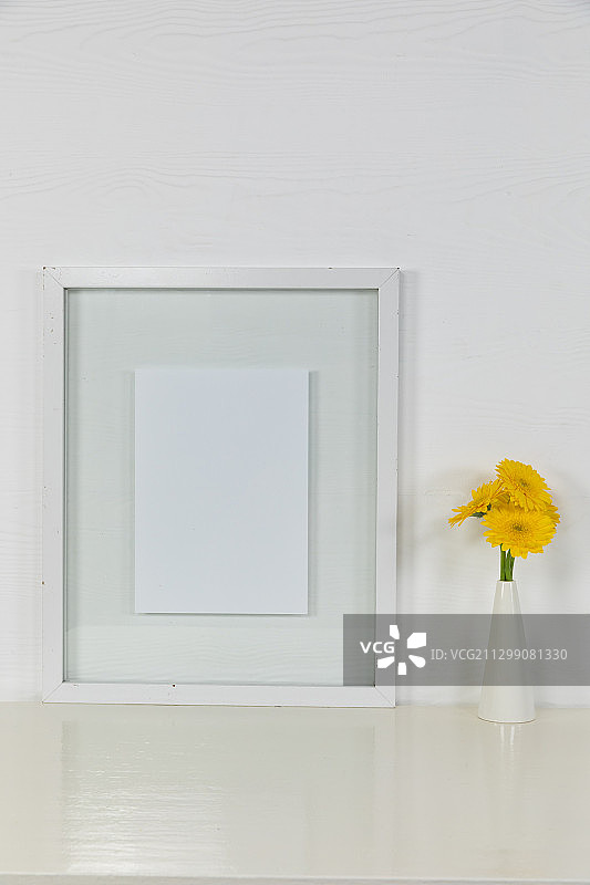 相框的视图，黄色郁金香放置在纯白色背景的玻璃花瓶中图片素材