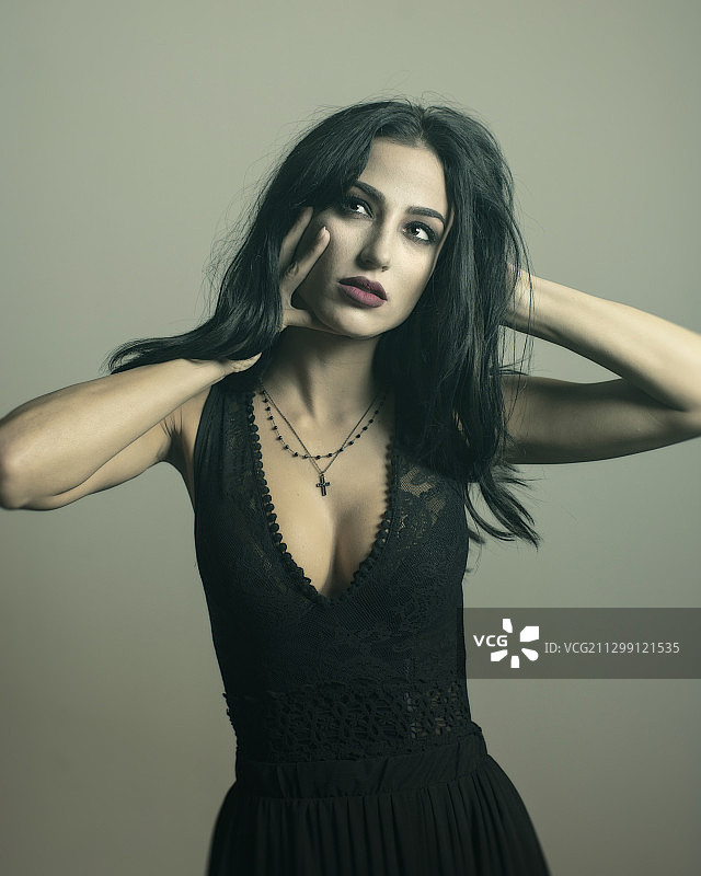 站在灰色背景前的年轻女子肖像，美国哈姆特拉克图片素材