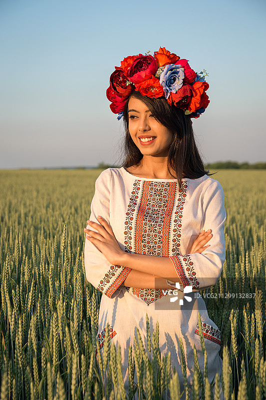 年轻女子头戴花环站在田野中，乌克兰伊万诺-弗兰科夫斯克图片素材