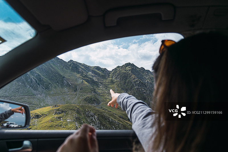 在车窗前指向山脉的女人，罗马尼亚克卢日-纳波卡图片素材