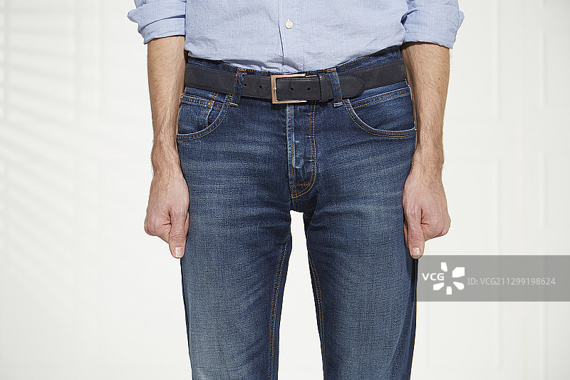 双手紧握身体的男人（肢体语言：不安或愤怒）图片素材