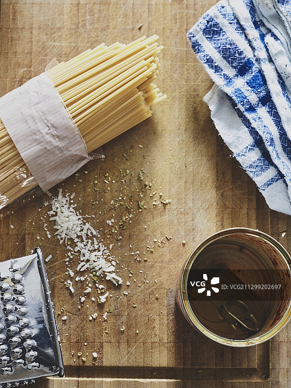 未煮意大利面、剩余香草和磨碎的奶酪与空罐头图片素材