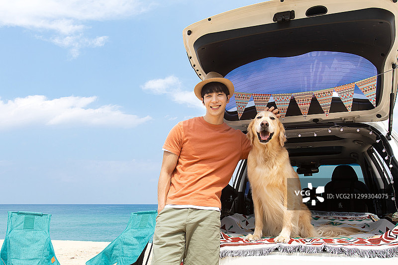 男人和他的金毛宠物狗在户外露营旅行图片素材