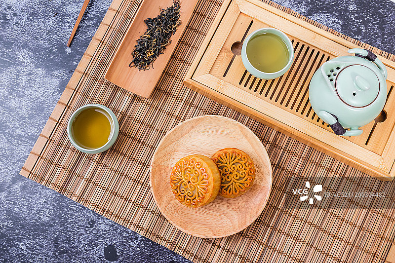竹席上摆放的茶具和中秋节月饼图片素材
