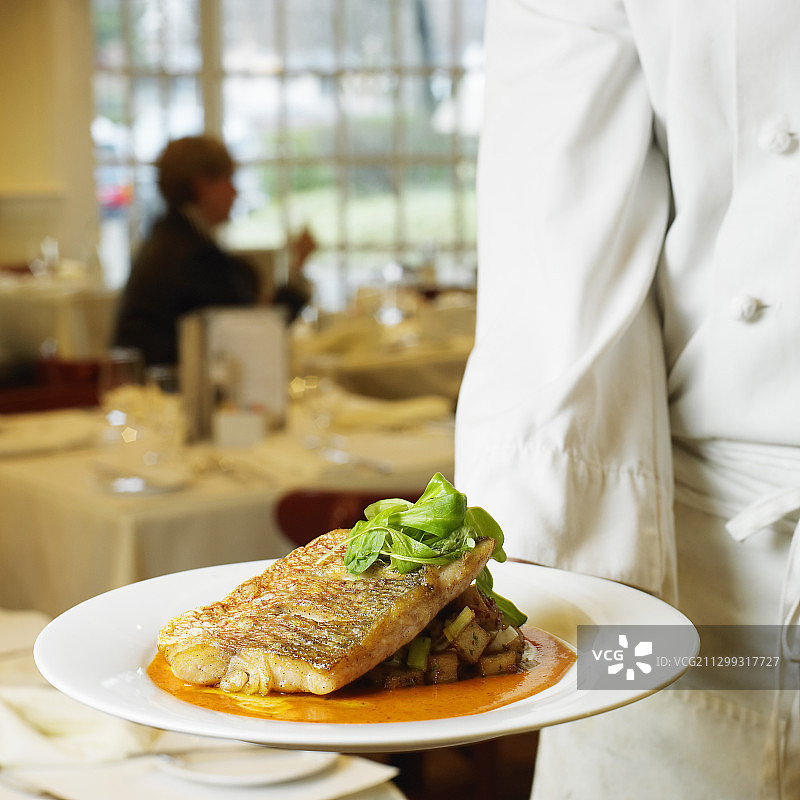 厨师在餐厅供应香草土豆红鲷鱼图片素材