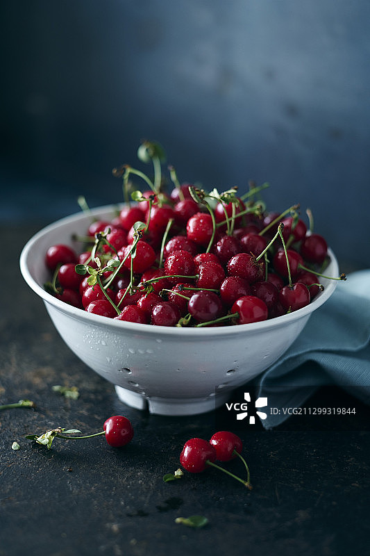 瓷筛中新鲜采摘的酸樱桃图片素材
