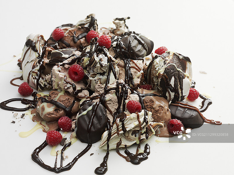 堆满糖果、巧克力酱和覆盆子的冰淇淋图片素材