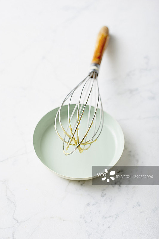 搅拌器上搅拌好的蛋糕混合物靠在盘子上图片素材