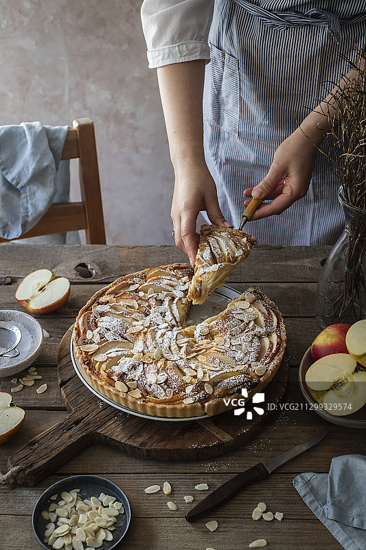 女人上菜：撒杏仁片苹果杏仁馅饼图片素材