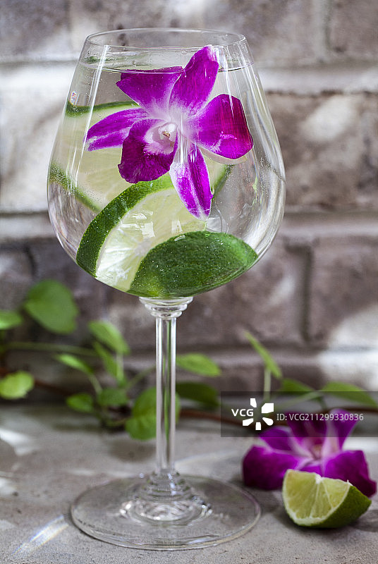 户外餐桌上装饰着酸橙和食用花的苏打水图片素材