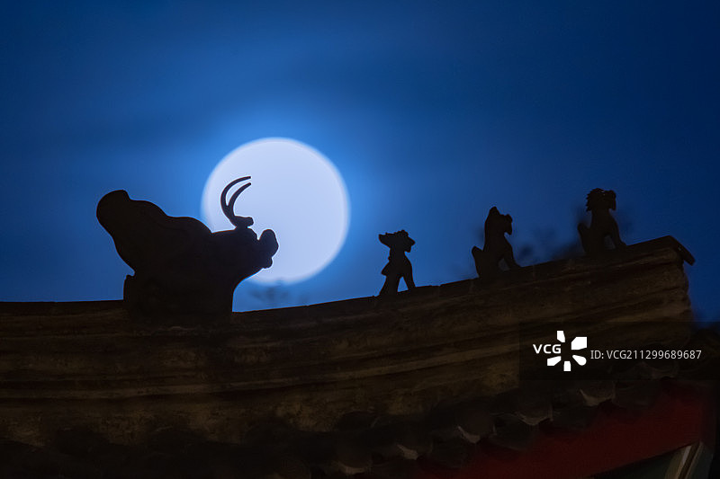 2020年6月5日，北京街头古建筑，满月从屋檐脊兽背后升起。图片素材