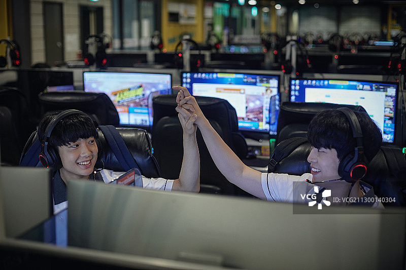 青少年在网吧用电脑戴着耳机图片素材