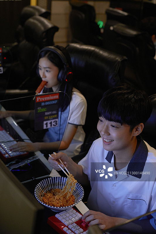 青少年学生在网吧吃零食、方便面图片素材