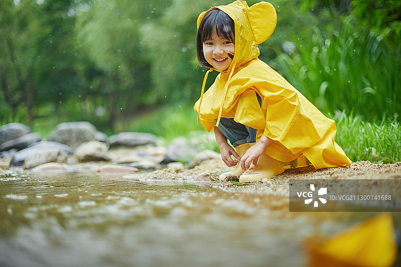 雨中穿雨衣玩耍的可爱女孩图片素材