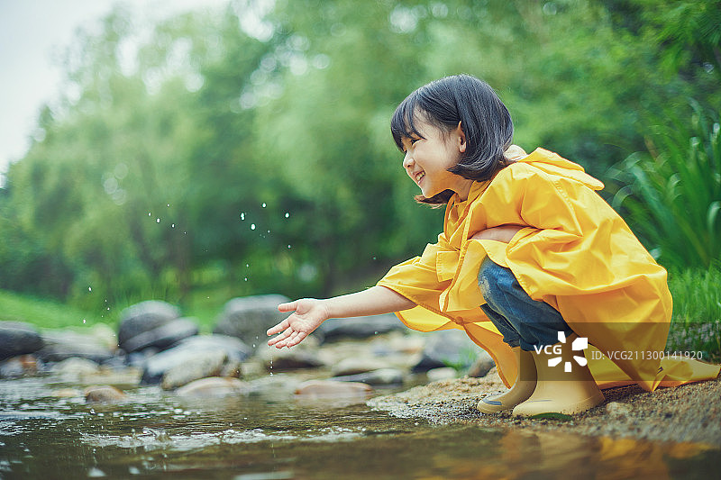 雨中玩耍的女孩：穿着雨衣图片素材
