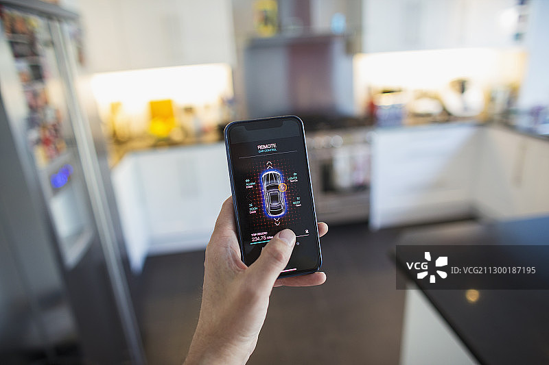 男人在厨房通过智能手机屏幕启动汽车报警器的主观镜头图片素材