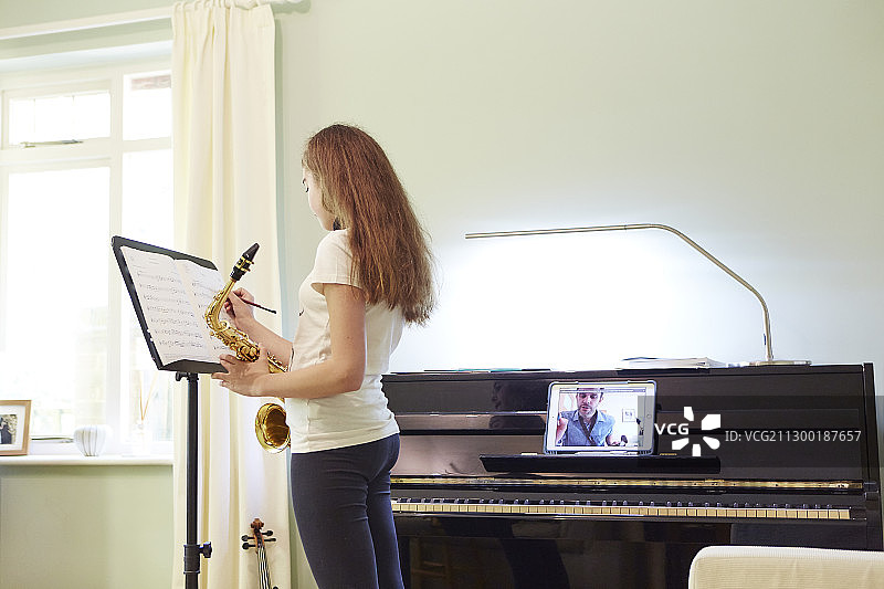 女孩在家上在线萨克斯课程图片素材