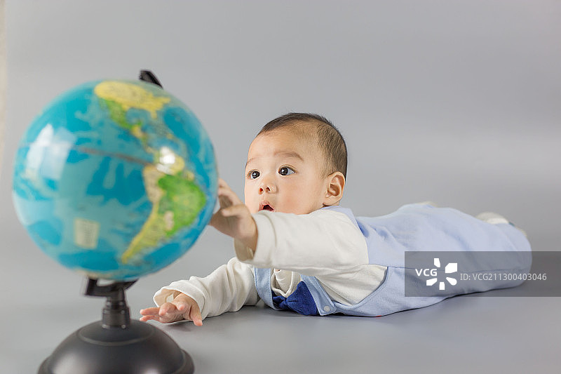 触摸地球仪的中国小宝宝图片素材