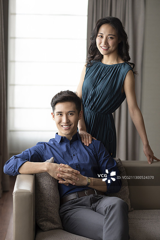 快乐的年轻夫妇在客厅度过美好时光图片素材