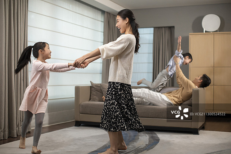 快乐的年轻家庭在客厅玩耍图片素材