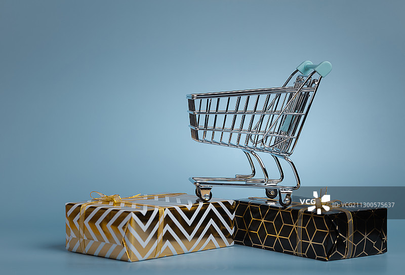 蓝色背景购物车与金色礼物盒图片素材