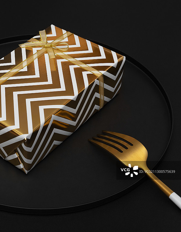 黑色背景盘子里的黑金礼物盒与叉子图片素材