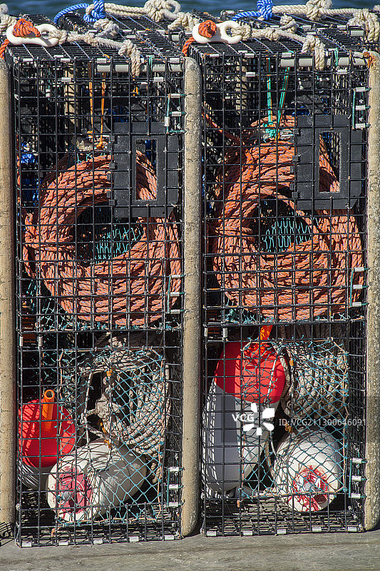 码头上堆放着装满绳索和浮标的龙虾捕捞笼图片素材