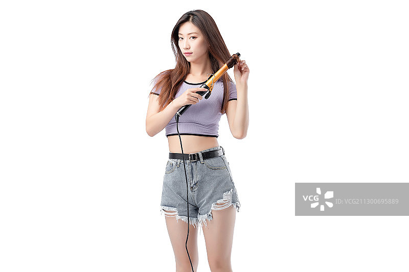 白色背景里,正在烫卷发的时尚亚洲女孩图片素材