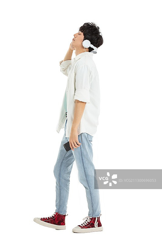 带着耳机手拿手机的年轻男生图片素材