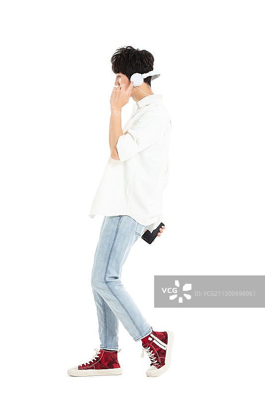 带着耳机手拿手机的年轻男生图片素材