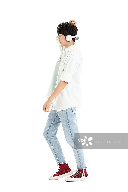 带着耳机手拿手机的年轻男生图片素材