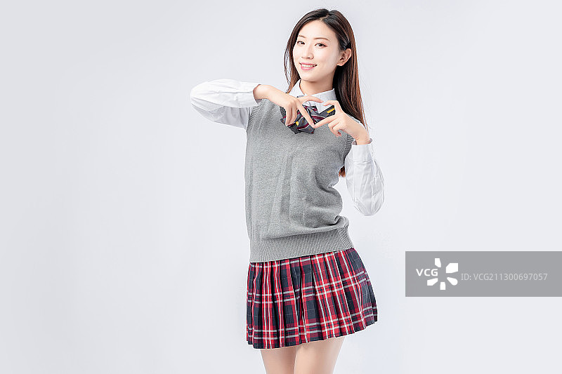 纯色背景里,身穿校服的亚洲女孩图片素材