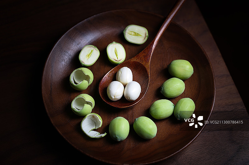 复古风格的放在木盘子里的新鲜莲子图片素材