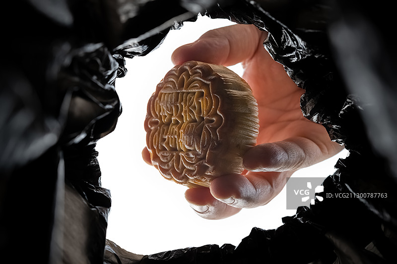 向垃圾桶里投入全新没吃过的月饼图片素材