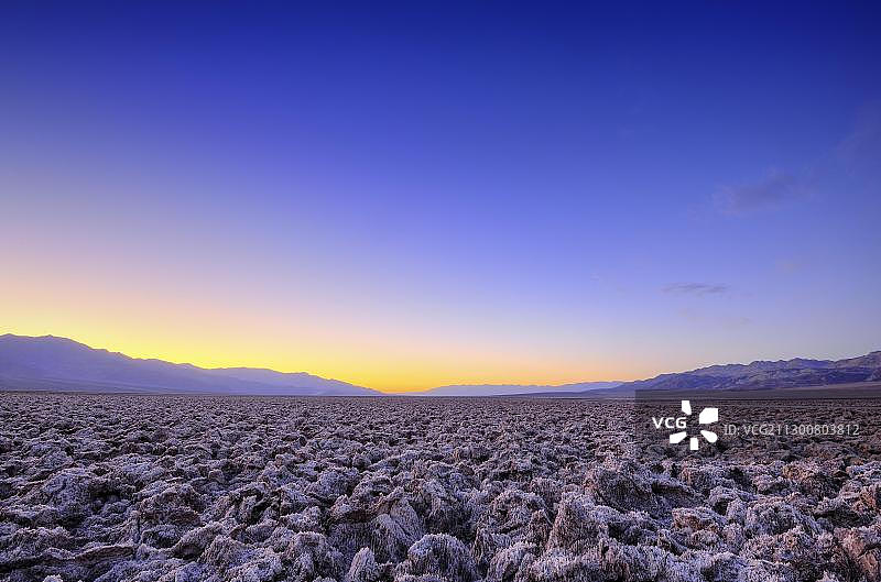 恶魔高尔夫球场的盐壳，日落，帕纳明特山脉，黑山，死亡谷国家公园，莫哈韦沙漠，加利福尼亚州，美国图片素材