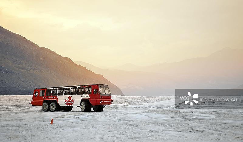 黄昏时分,游客乘坐布鲁斯特专用巴士、冰原探险家雪地车和雪地摩托探索冰川,阿萨巴斯卡冰川,哥伦比亚冰原,冰原大道,贾斯珀国家公园,加拿大落基山脉,落基山脉,艾伯塔省,加拿大,北美图片素材