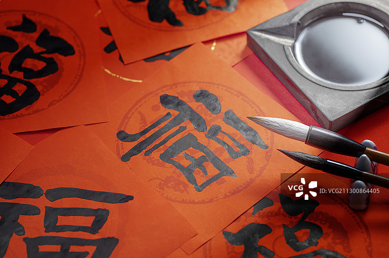 毛笔和砚台放在写好的福字春联旁边图片素材