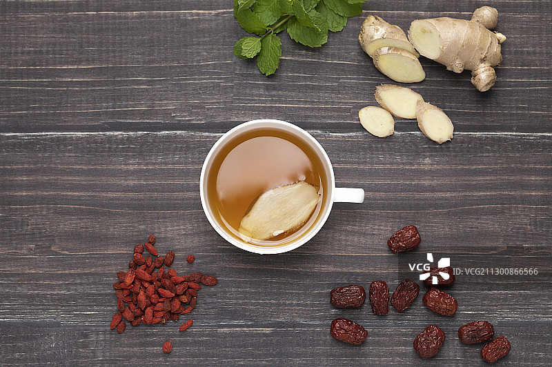 桌上放着红枣枸杞和一杯养生的姜茶图片素材
