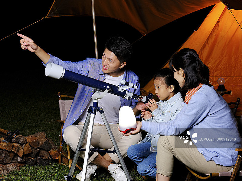 快乐的三口之家在户外使用天文望远镜图片素材
