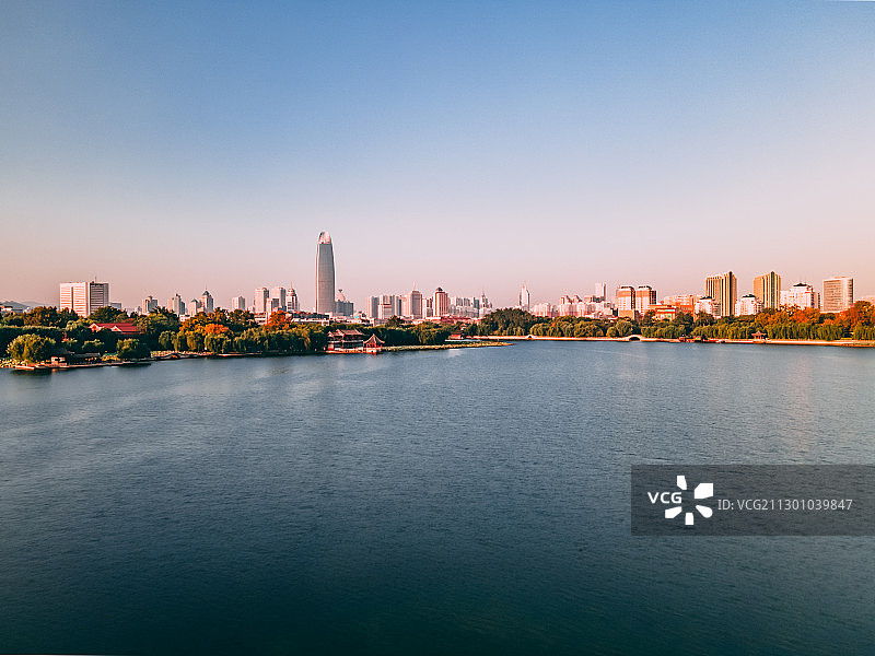 航拍山东省济南市大明湖风景区与远处的城市建筑图片素材