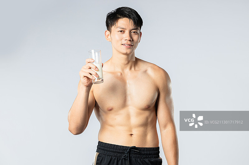 正在喝牛奶的健身肌肉男孩图片素材