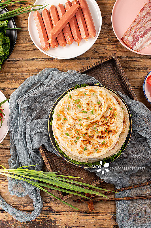 木板背景上美味小吃手抓饼图片素材